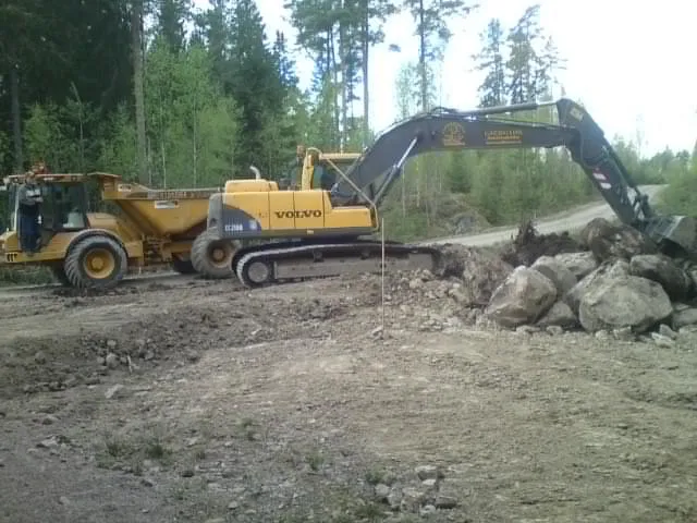 Grävmaskin och dumper vid en skogsväg